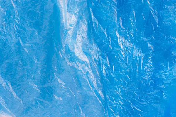 Parlak mavi plastik çöp torbasının dokusu yakın. Buruşmuş selofan. Violet polietilen film geçmişi. Ekoloji problemi.