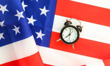 Alarm clock on American flag. President elections, Memorial Day, 4th of July or Labour Day concept. Patriotism and independence. Time to vote. clipart