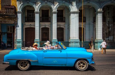 Havana, Küba, Temmuz 2019, açık mavi Chevrolet araba şehrin en eski bölgesinde Belgiga Bulvarı 'nda sürüyor.