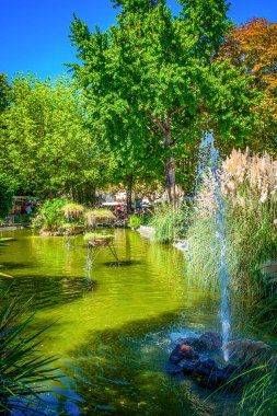 View of a pond with a fountain in Cassis public park on Place Baragnon