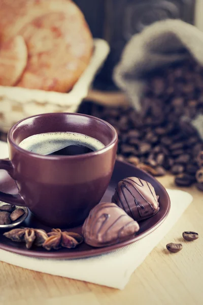 Tasse café avec des haricots et des bonbons au chocolat — Photo