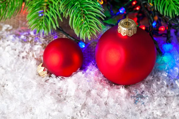 Bolas de Navidad en la blanca nieve con abeto de rama — Foto de Stock