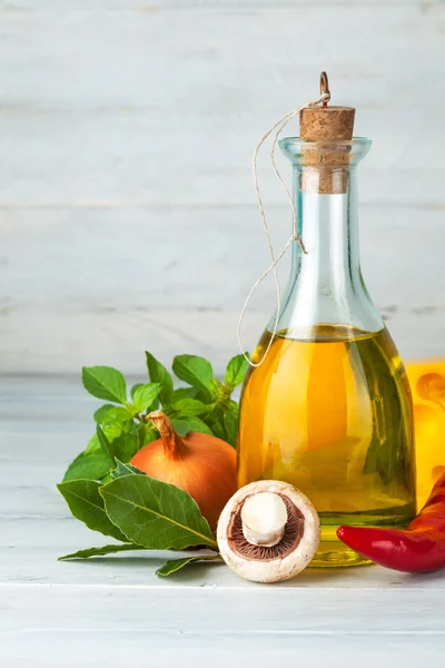Olivolja med kryddor och grönsaker på träskiva — Stockfoto