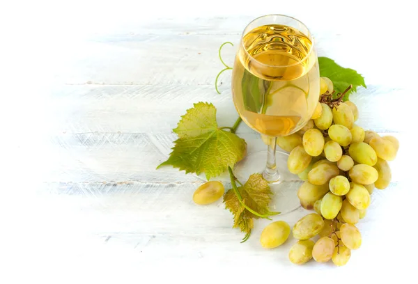 Ποτήρι λευκό κρασί με σταφύλια και φύλλα σε σανίδα — Φωτογραφία Αρχείου