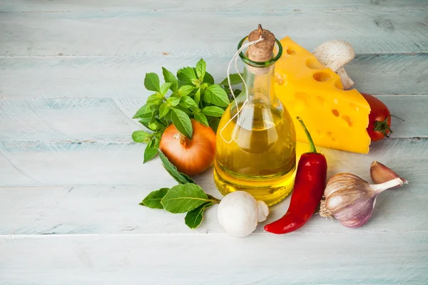 Olive oil with spices and vegetables on wooden board — Stock Photo, Image
