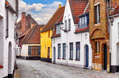 Bruges, Belçika. Eski ortaçağ şehrinin kaldırım taşları olan tuğla duvarlı antik evler. Geleneksel Belçika evleri. Akşam gökyüzü.