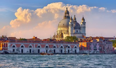 İtalya, Venedik 'te Büyük Kanal. Manzaralı manzara şehrinde panoramik manzara ve Santa Maria della katedral katedralini selamlıyor. Su taksisi motorlu tekneleri su üstünde kesiyor. Dramatik bulutlarla gün batımı gökyüzü..