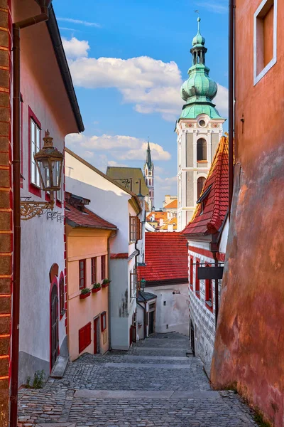 Cesky Krumlov, Çek Cumhuriyeti. Dar sokaktan kilise kulesine bakın. Antik bohem köyünde antik evlere sahip ortaçağ mimarisi ve fenerler var. Akşam vakti romantik bir yer..