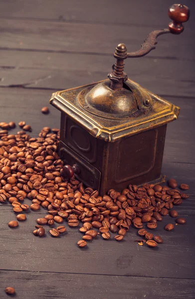 Old vintage coffee mill on roasted hot beans — Stock Photo, Image