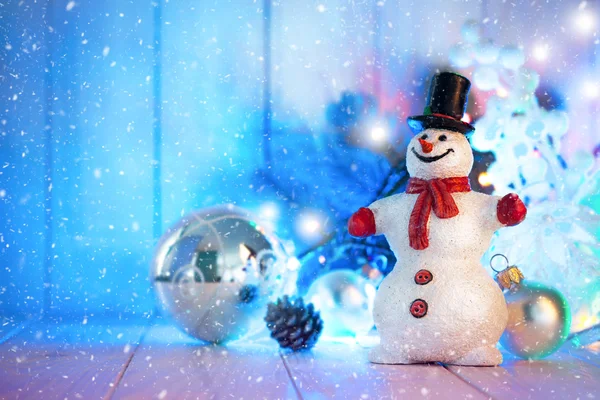 Muñeco de nieve de Navidad con bolas y guirnaldas en tablero de madera — Foto de Stock