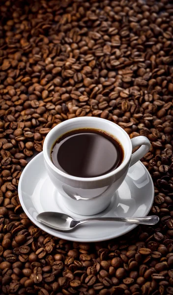 Кубок с ароматным кофе напиток на фоне фасоли — стоковое фото