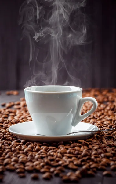 Bebida café aromática caliente en la taza blanca con granos de fondo —  Fotos de Stock