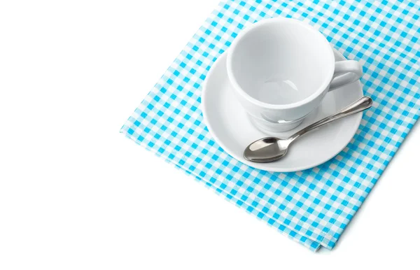 Tasse à café blanche avec soucoupe et cuillère vaisselle sur serviette damier bleu — Photo