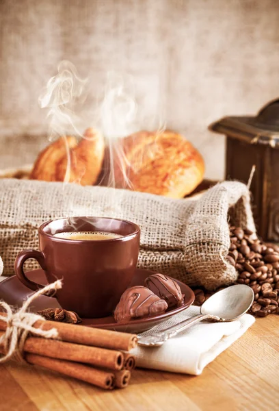 Cup hot coffee with beans and chocolate candies — Stock Photo, Image