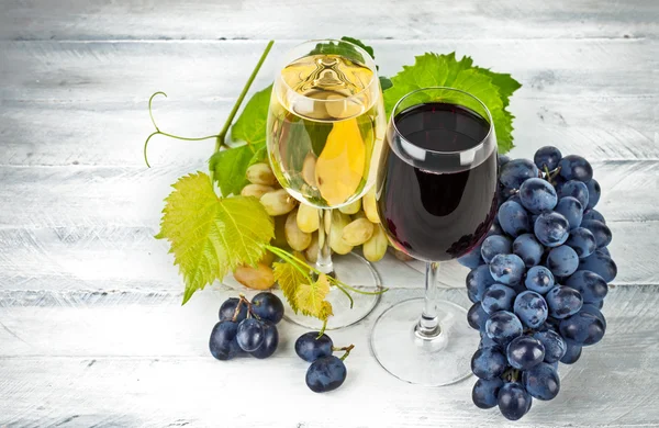O vinho no copo de vinho com uvas — Fotografia de Stock