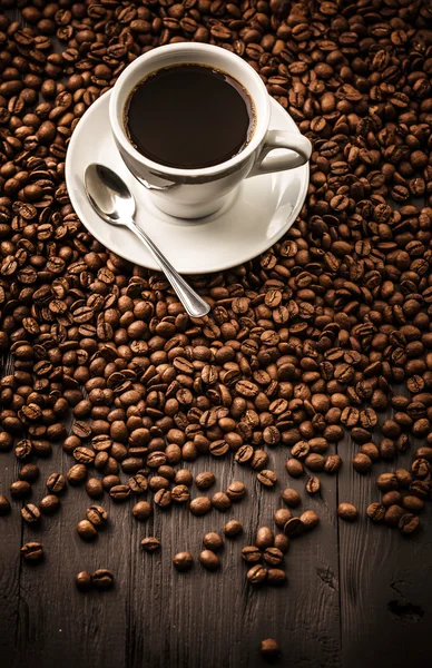 Tasse Kaffee Draufsicht auf Bohnen-Hintergrund — Stockfoto