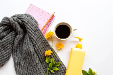 İş için not defteri planlayıcısı sıcak kahve, yün örgü atkı ve yaşam tarzı düzenleme vücut losyonu arka plan beyaz üzerine yatıyordu