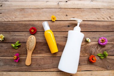 Hasarlı saçlar için şampuan, saç bakım serumu ve taraklı sağlık hizmetleri güzellik saçı ve yaşam tarzı kadın düzenleme düzleştirici arka plan tahtasının üzerinde düz bir şekilde yatıyordu.