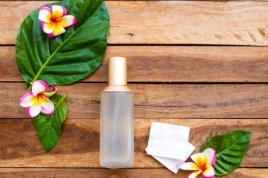 İlk terapi olan pamuk doğal kozmetik içeren serum tonerleri cilt için bitkisel sağlık hizmetleri sunar. Kadın yüzü güzelliği ve yaprak düzenleme düzleştirici arka plan tahtasının üzerinde düz bir şekilde yatar.