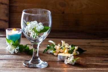 Kandil düzenleme ile cam içinde beyaz çiçekler yasemin düz arka plan ahşap üzerine yatıyordu kartpostal tarzı