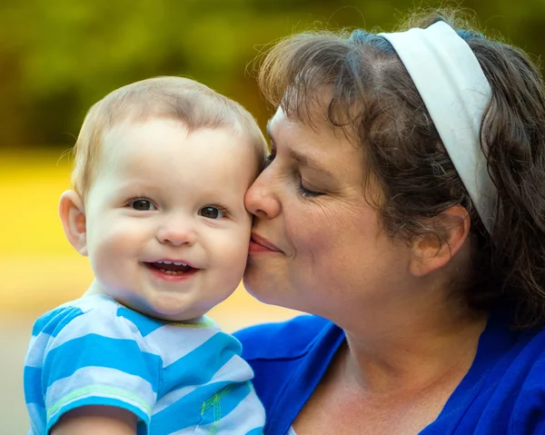 Szczęśliwe dziecko pocałował przez mama — Zdjęcie stockowe