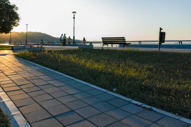 GOLUBAC, SERBIA - 11 Ağustos 2019: Sırbistan 'ın Golubac kentindeki Costal Caddesi ve Tuna Nehri' nin şaşırtıcı Günbatımı manzarası