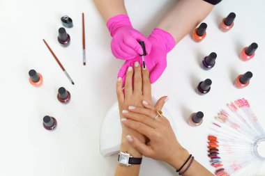 Manicurist treating client at beauty nails salon. Manicure, painting on nail clipart