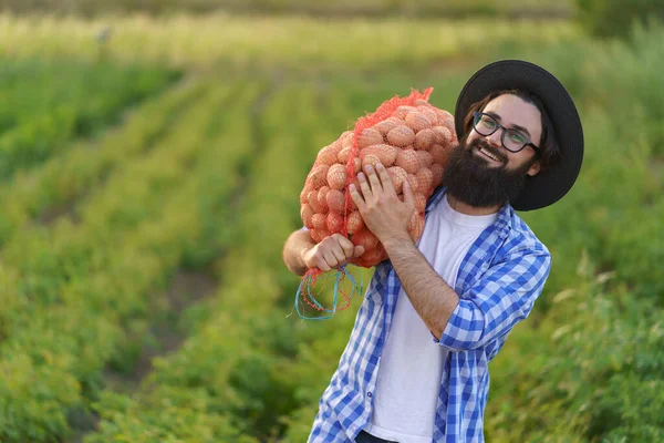 Фермер тримає мішок картоплі на плечі — стокове фото