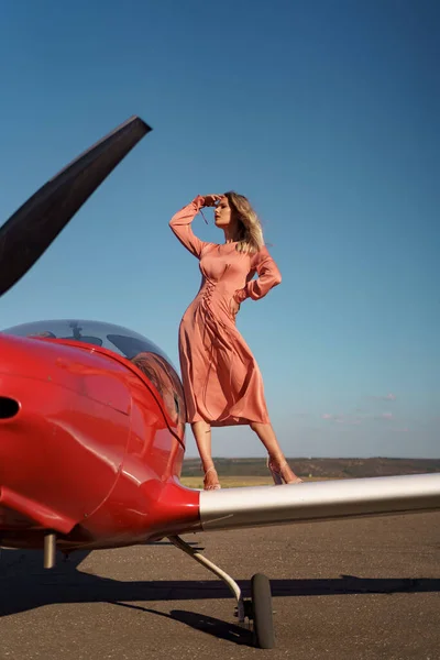 Mooie vrouw poseren in roze zijden jurk — Stockfoto