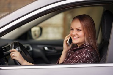 Güzel bayan sürücü telefonda konuşuyor..