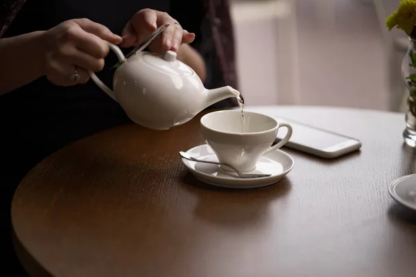Kobiece dłonie nalewające herbaty — Zdjęcie stockowe
