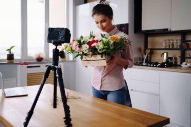 Blog 'unda eve çevrimiçi ders vermek için kamera kullanan bir kadın