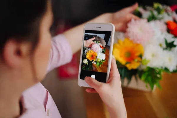 Mujer tomando foto composición de flores en el teléfono inteligente —  Fotos de Stock