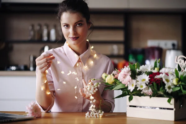 Florista mujer piensa cómo decorar flores con luces led — Foto de Stock