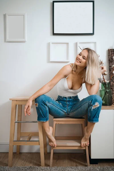 Blonde vrouw portret zitten in moderne interieur — Stockfoto