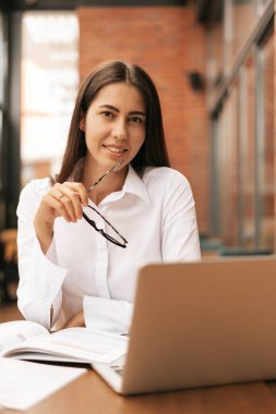 İşine odaklan. Genç ve güzel bir kadın otururken dizüstü bilgisayarını kullanıyor. Güzel, zeki, sevimli, çekici, zarif bayan ev sahibi içeride online toplantı yapıyor.