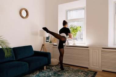 Çiçekleri sularken bale yapan güzel bir bayan.