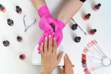 Güzellik salonunda manikürcü müşteriyi tedavi ediyor. Manikür, çivi boyası.