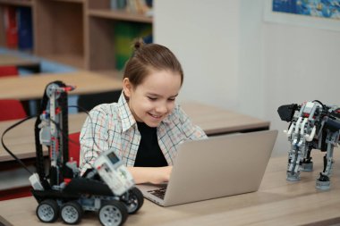 Çocuk tam fonksiyonel robot yapıyor ve bunu okul robotları için dizüstü bilgisayarla programlıyor.