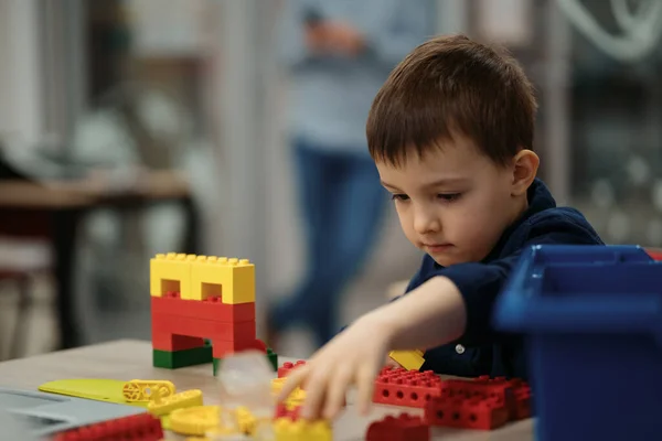 小さな男の子がロボットを作って遊ぶ. — ストック写真