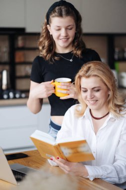 Anne ve kızı bir kitabı tartışıyor.