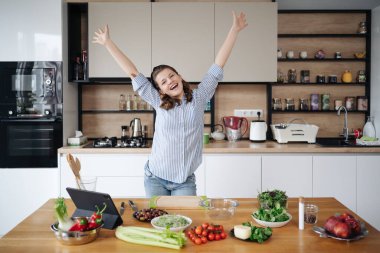 Yemek pişirirken el ele tutuşup dans eden neşeli kız.