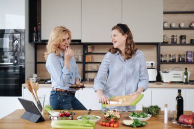 Anne ve kızı birlikte yemek pişiriyorlar.