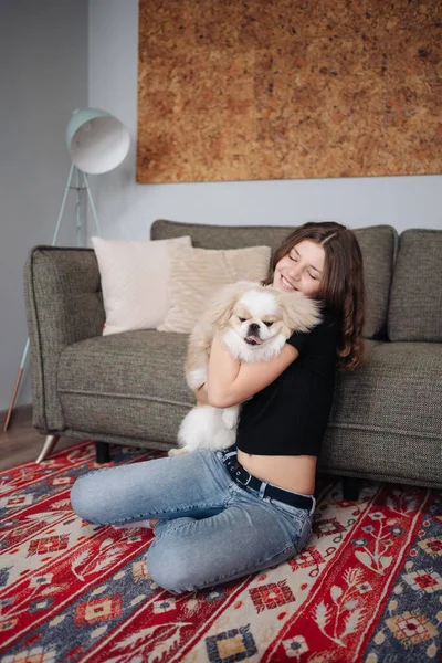 Jovem mulher abraçando seu animal de estimação cachorrinho — Fotografia de Stock