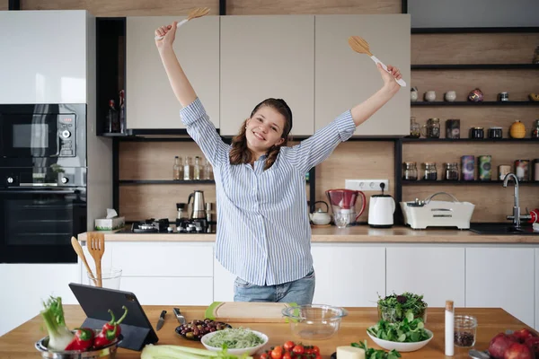 Chica alegre bailando mientras cocina cogida de la mano — Foto de Stock