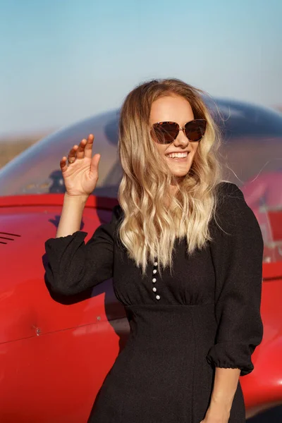 Glamoureuze vrouw poseren op vliegtuig achtergrond — Stockfoto