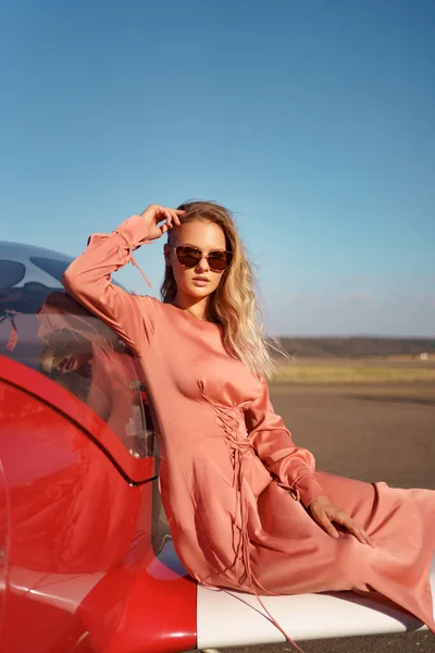 Mooie vrouw poseren in roze zijden jurk — Stockfoto