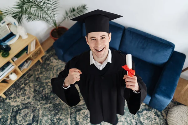 Beyaz tenli genç adam bekarlık diplomasını aldığı için çok heyecanlı. — Stok fotoğraf