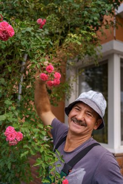 Bahçede son sınıf öğrencisi gül kesiyor.