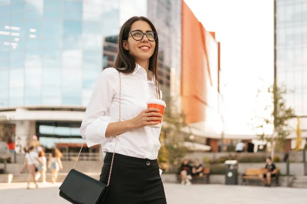 Mulher de camisa branca segurando um café para ir — Fotografia de Stock